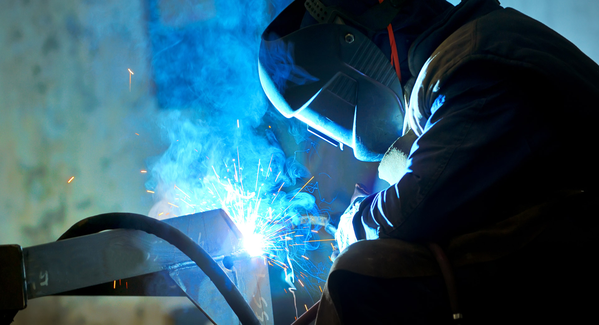 A worker wearing a blowtorch helmet doing structural fabrication in Queensland